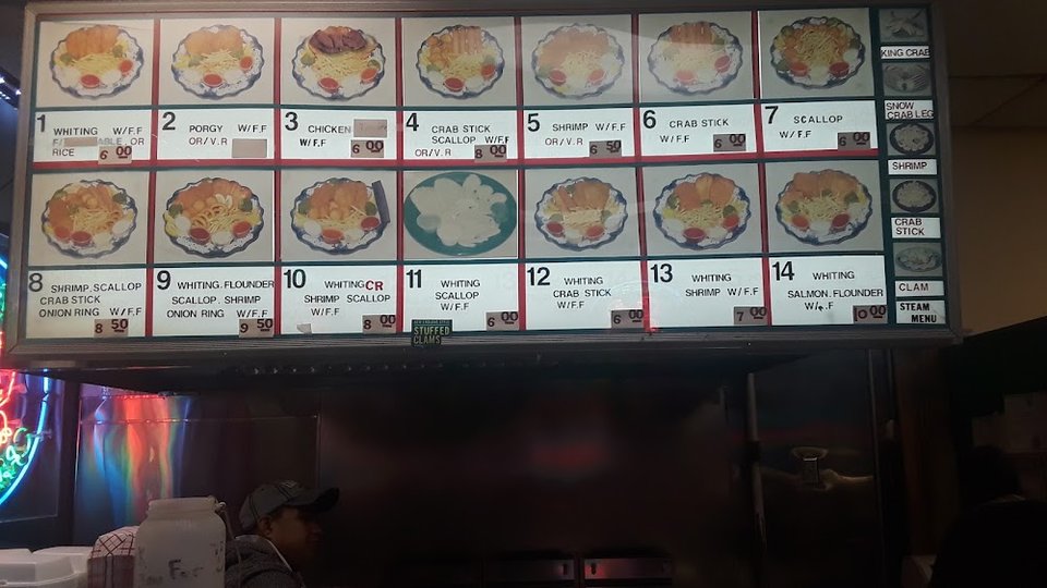 Printed menu beside fried fish selections.